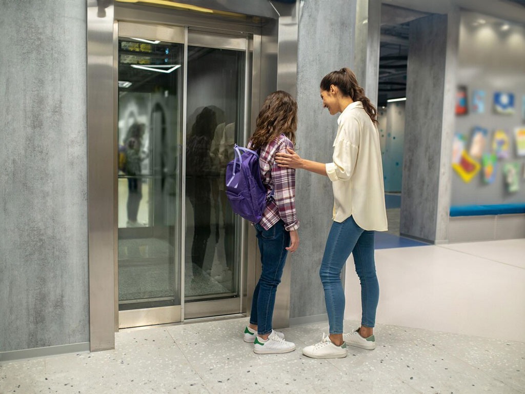 Madre e hija usando ascensor moderno